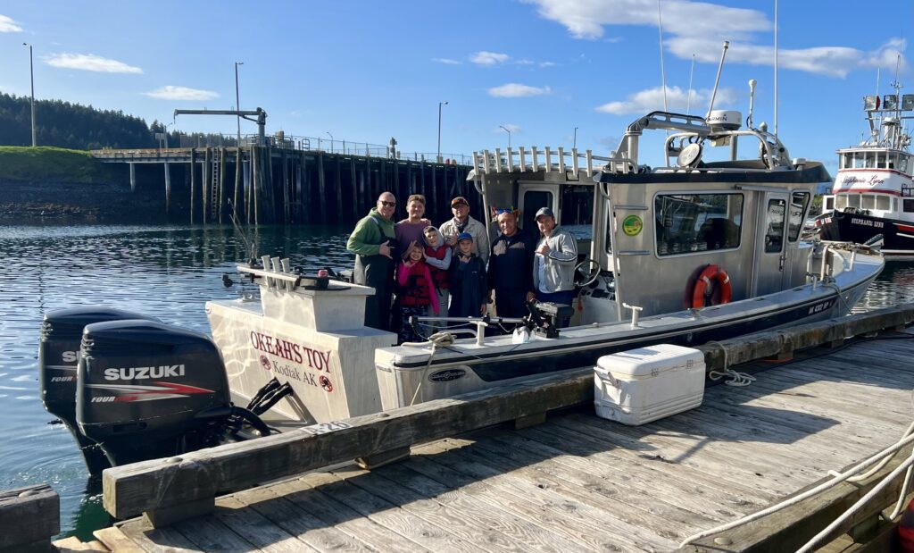 A family on a fishing boat posing for a picture.