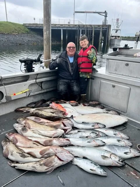 Two people sitting on a boat with fish