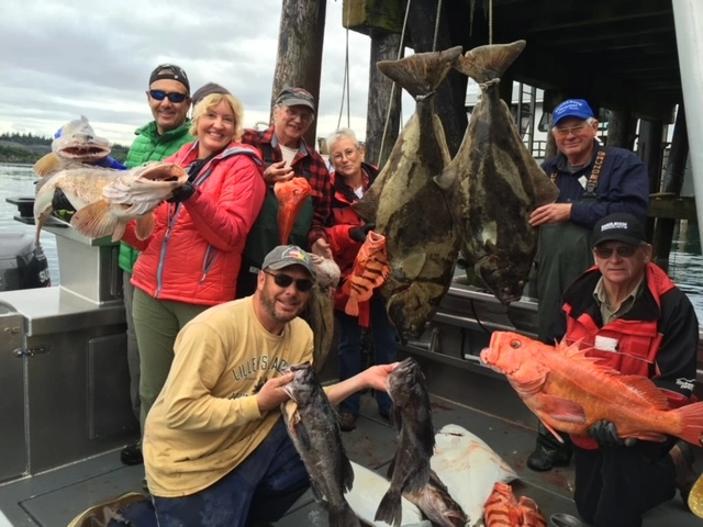 A group of people standing around holding fish.